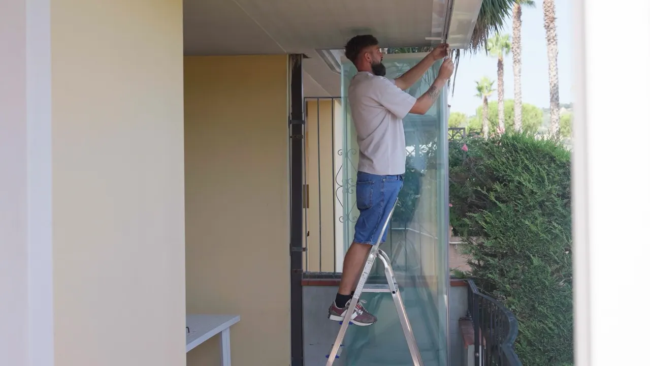 A Diva Infissi fitter working on a unit from a balcony