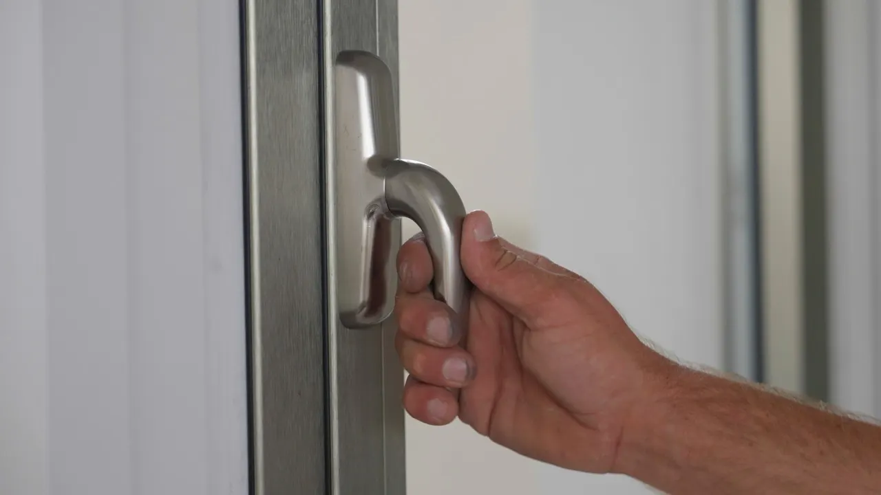 Handle of an aluminium sliding unit being opened by hand