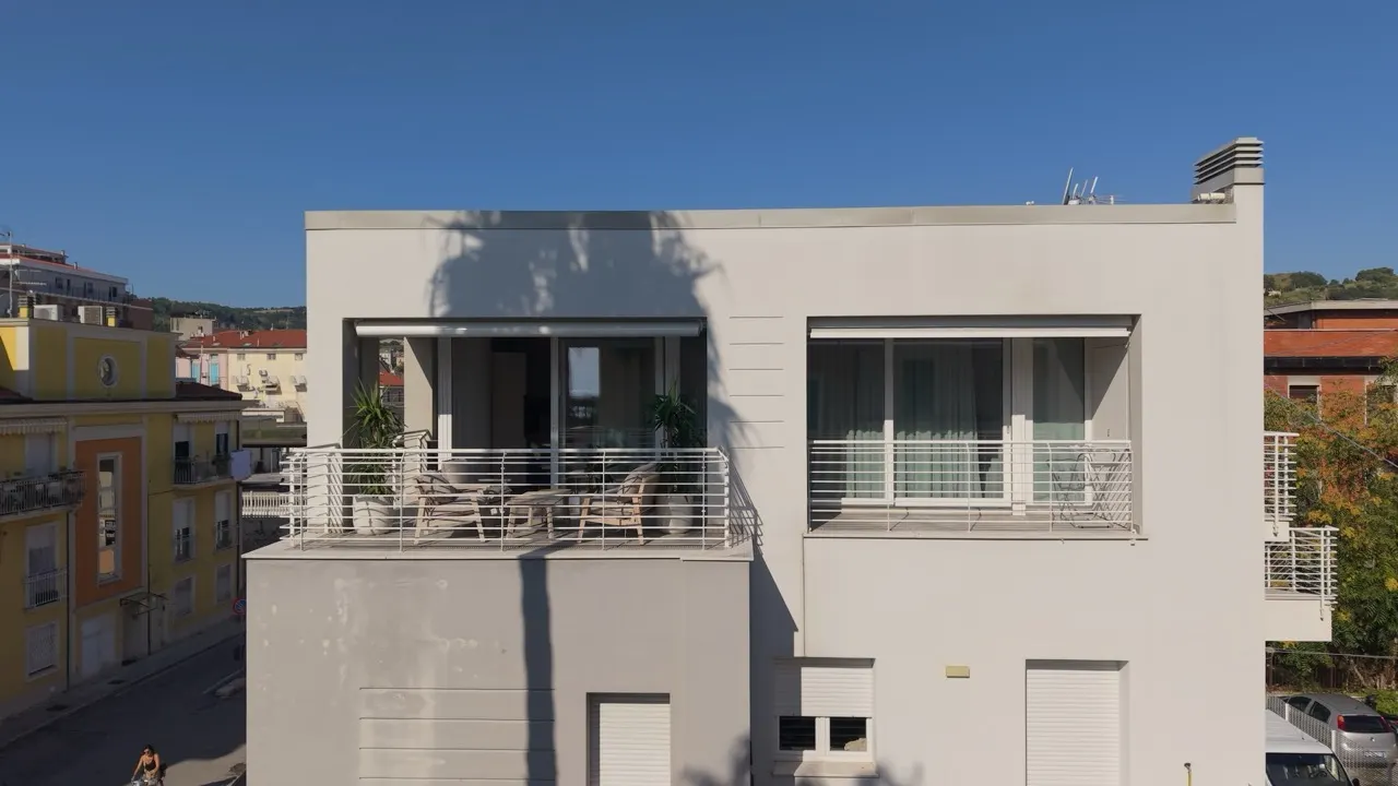 Light-coloured roller shutters on a facade facing the sea