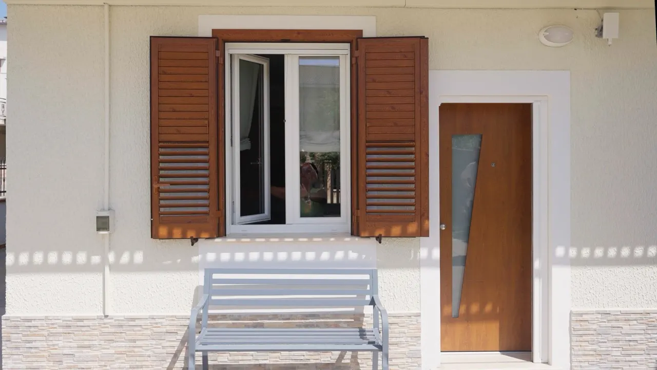 Facade with wooden shutters, a window and the front door