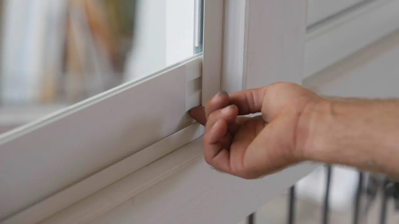 Gasket of a uPVC window being checked by hand